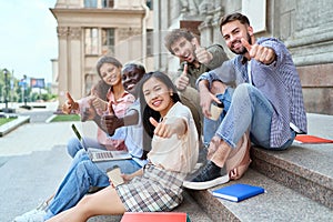 multicultural team of students showing thumbs up.