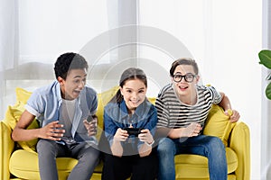 multicultural teen boys supporting friend playing video game