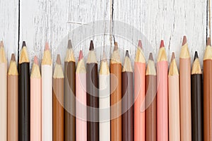 Multiculture skin tone color pencils background on weathered wood photo