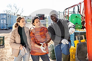 Multiethnic agriculturists having conversation during break outdoors