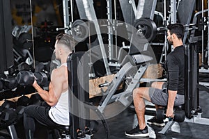 Multiethnic athletic sportsmen training with dumbbells