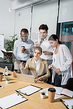 multiethnic business people looking at laptop