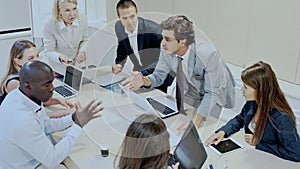 Multiethnic business team having emotional discussion on staff meeting at office