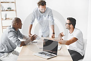 multiethnic businessmen discussing new business idea at workplace