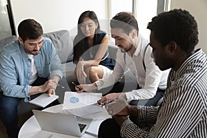 Multiethnic businesspeople brainstorm discussing paperwork at meeting