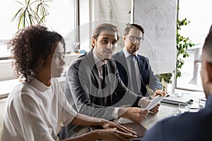 Multiethnic businesspeople brainstorm at meeting in office boardroom