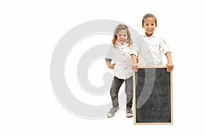 Multiethnic children with long hair hold a whiteboard with their hands