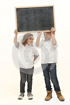 Multiethnic children with long hair hold a whiteboard with their hands