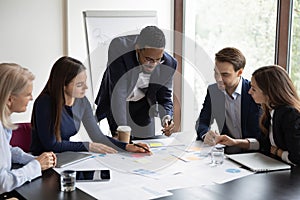 Multiethnic colleagues brainstorm at team meeting in office