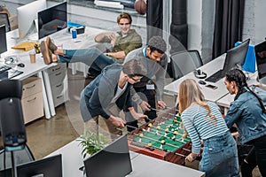 multiethnic colleagues playing in table soccer