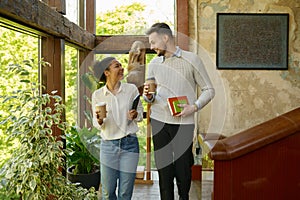 Multiethnic colleagues taking coffee break walking in eco-friendly office