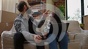 Multiethnic couple finding home decor inspiration on laptop