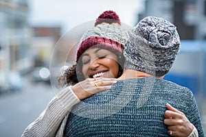 Multiethnic couple hugging outdoor in winter