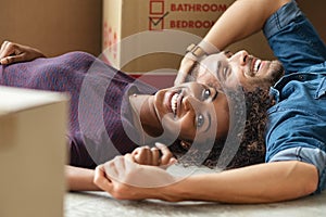 Multiethnic couple lying on floor after moving house