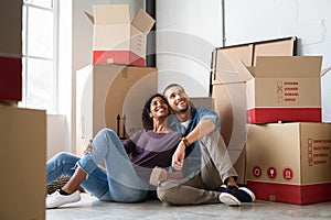 Multiethnic couple in new home with boxes