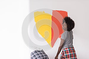 Multiethnic couple painting interior wall