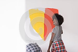 Multiethnic couple painting interior wall