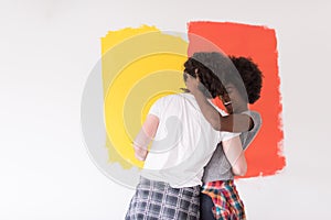 Multiethnic couple painting interior wall