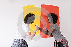 Multiethnic couple painting interior wall