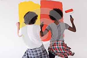 Multiethnic couple painting interior wall