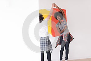 Multiethnic couple painting interior wall