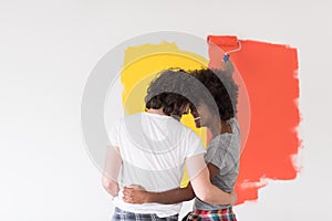 Multiethnic couple painting interior wall