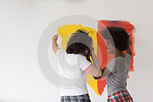 Multiethnic couple painting interior wall