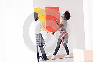 Multiethnic couple painting interior wall