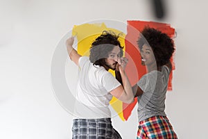 Multiethnic couple painting interior wall