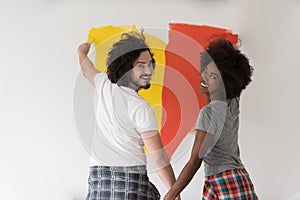 Multiethnic couple painting interior wall