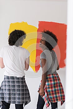 Multiethnic couple painting interior wall