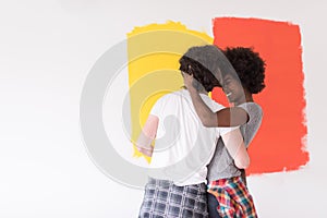 Multiethnic couple painting interior wall