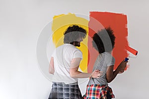 Multiethnic couple painting interior wall