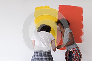 Multiethnic couple painting interior wall