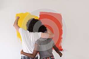 Multiethnic couple painting interior wall