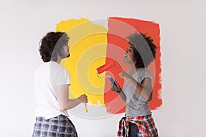 Multiethnic couple painting interior wall
