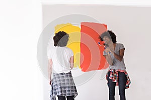 Multiethnic couple painting interior wall