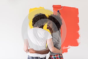 Multiethnic couple painting interior wall