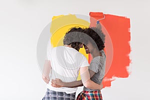 Multiethnic couple painting interior wall