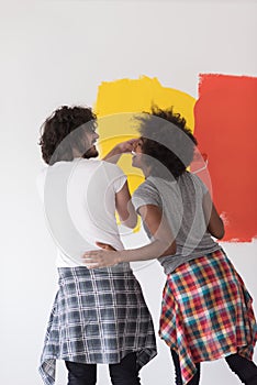 Multiethnic couple painting interior wall