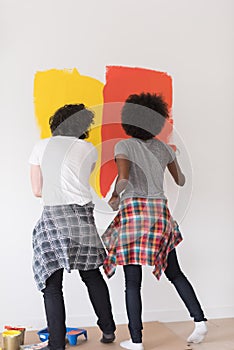 Multiethnic couple painting interior wall