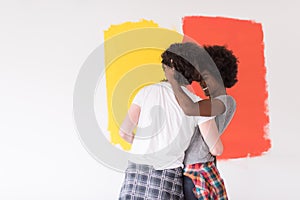 Multiethnic couple painting interior wall