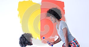 Multiethnic couple painting interior wall