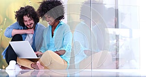 Multiethnic couple using a laptop on the floor