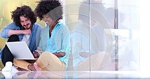 Multiethnic couple using a laptop on the floor