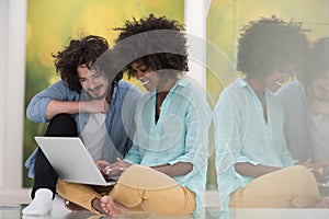 Multiethnic couple using a laptop on the floor