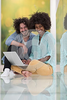 Multiethnic couple using a laptop on the floor