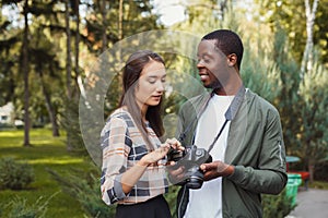 Multiethnic couple watching pictures on camera