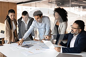 Multiethnic creative business group working on sales reports together