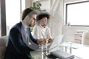 Multiethnic diverse colleagues brainstorm using laptop at briefing